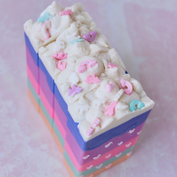 Rainbow soap with white glitter hearts on front and unicorn sprinkles on top