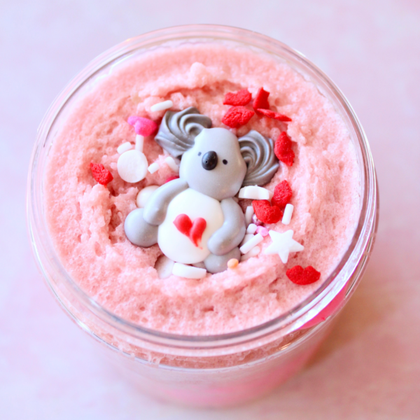 jar with Koala Bear sprinkle laying on a bed of red heart sprinkles and pink whipped sugar scrub.