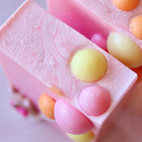 Pink soap with yellow and pink soap balls on top.