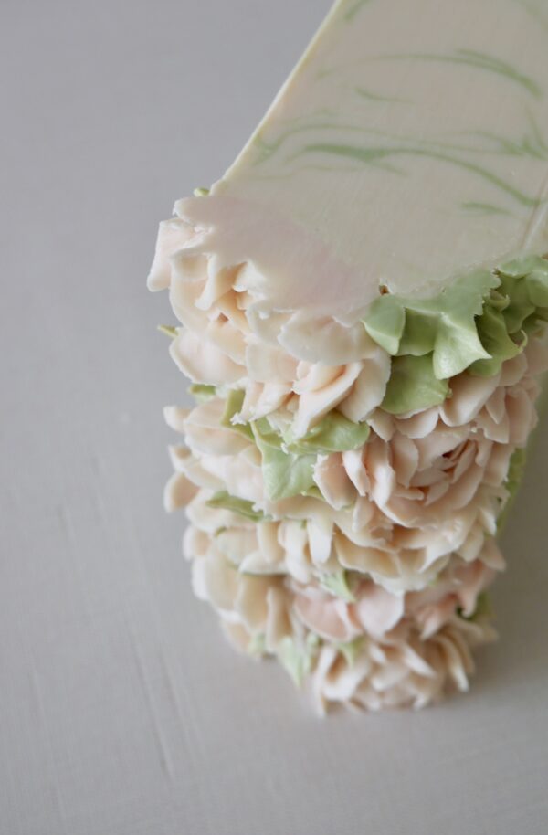Syacked bars of pink peony soap showing the piped flowers cut
