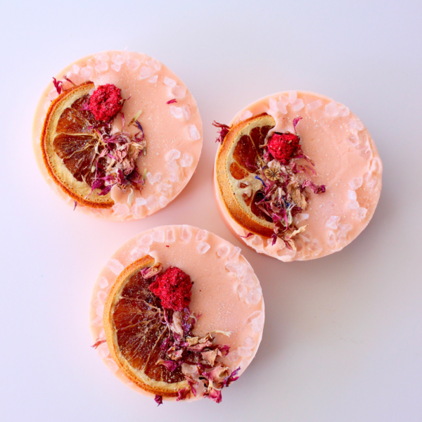 Blood Orange Margatita round soap bar with dried flowers, salt, and orange wedge on top