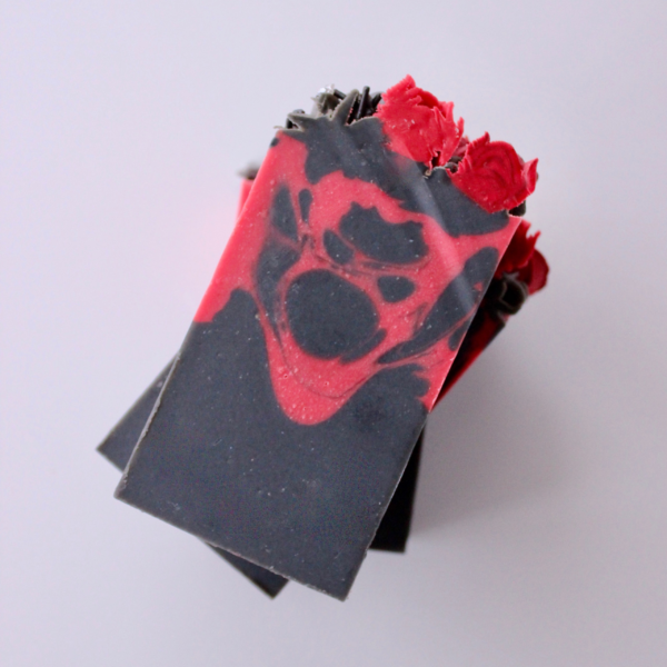 Vampire Kisses Bar stacked three on top of each other. The face of the bar has a black base with red swirls and red piped roses on top of bar.