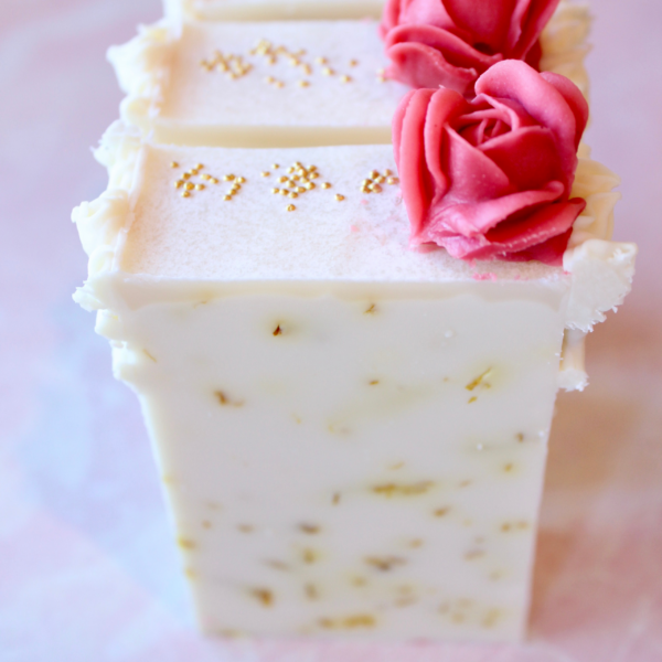 Pale yellow bar filled with calendula petals and red piped rose on top