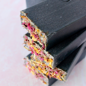 Black soap bar with various dried florals on top