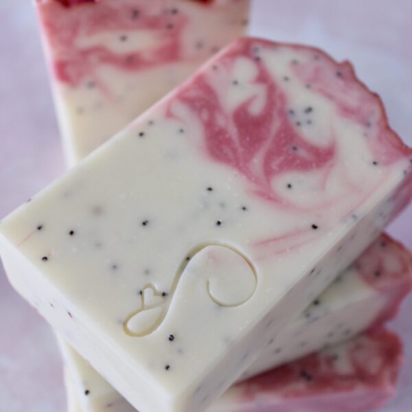 White dragonfruit soap bar with pink swirls and poppy seeds inside