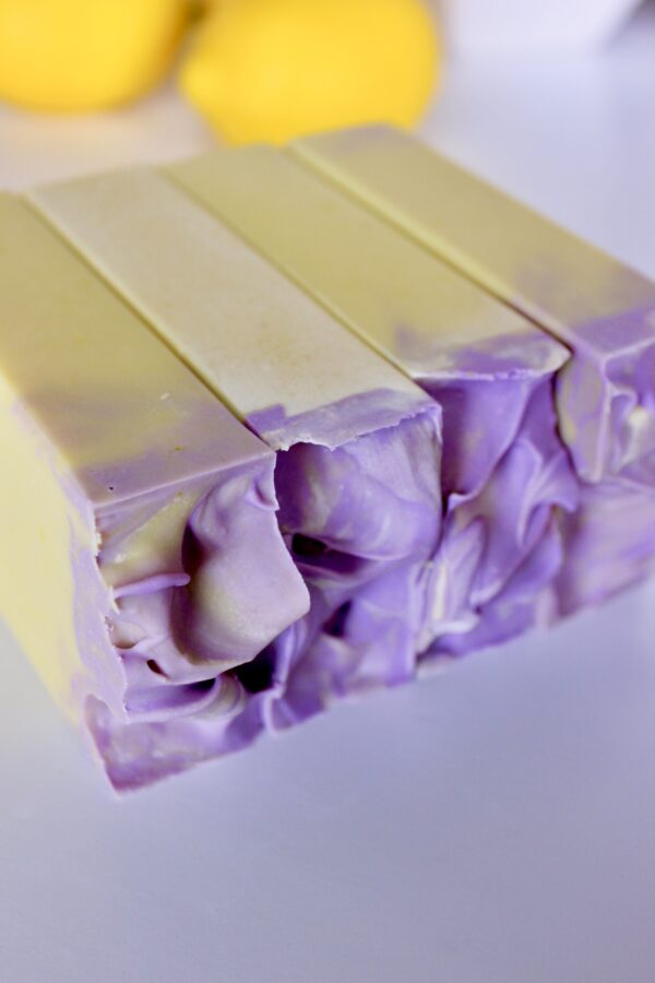 lemon lavender soap laying on side with lemons in background