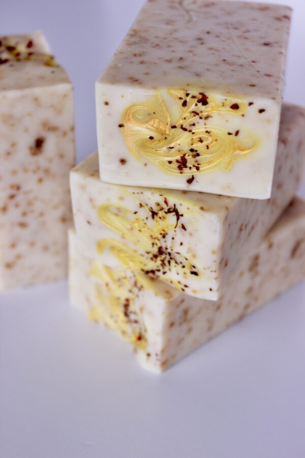 Three Citrus Sea Moss Butter Bars stacked on it's side showing yellow mica swirl and dried flowers on top